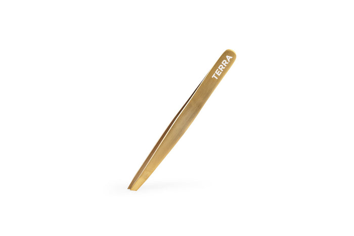 Gold-colored tweezers from the Terra Beauty Bars Beheld Eye Brow Kit sit on a white background, featuring TERRA near the tips for precision and elegance in your beauty routine.
