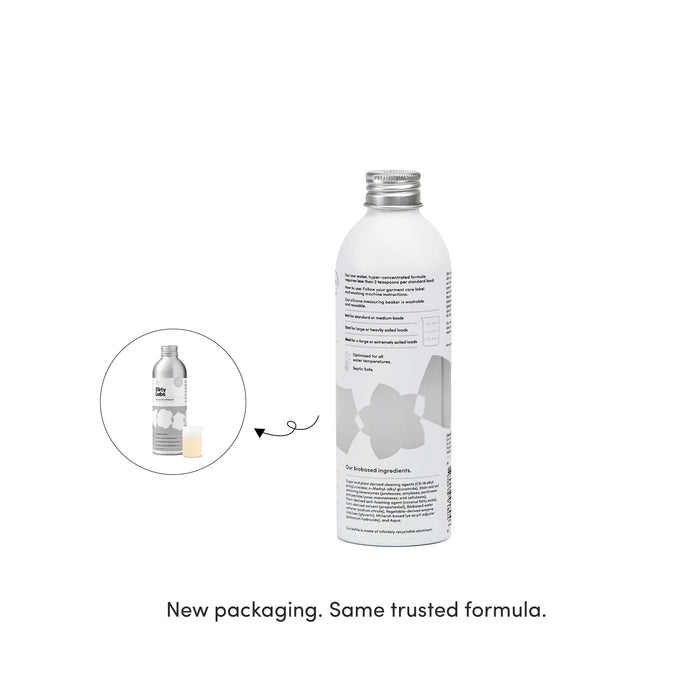A metallic bottle featuring a white label showcases Dirty Labs’ Bio Laundry Detergent with Phytolase® - Free & Clear. An inset displays the former packaging, with text below stating: New packaging. Same trusted formula.
