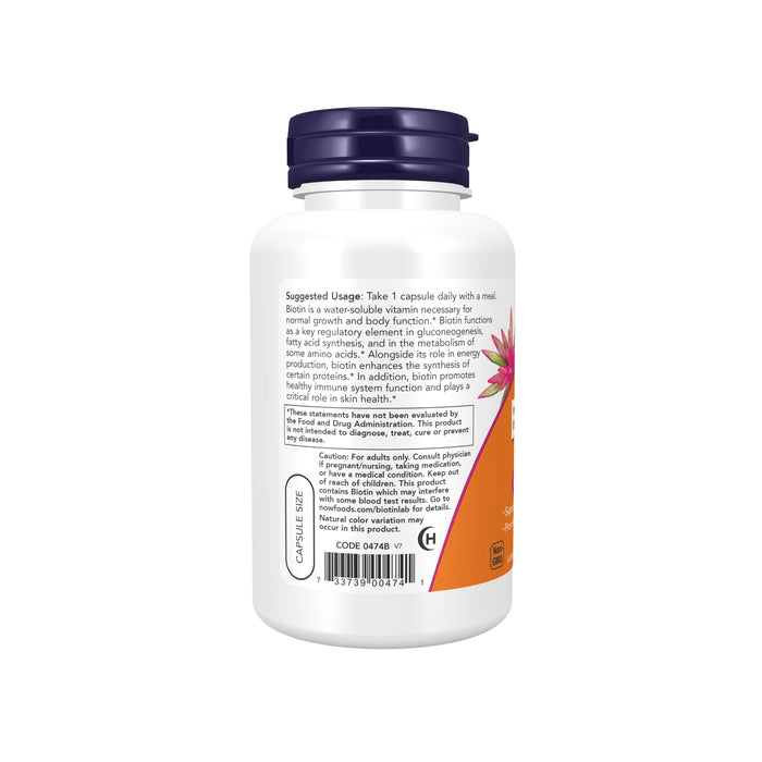 A white bottle with a dark blue cap carries a label with usage instructions and nutritional details. NOW Foods Biotin 5000mcg supplement supports energy production and skin health.