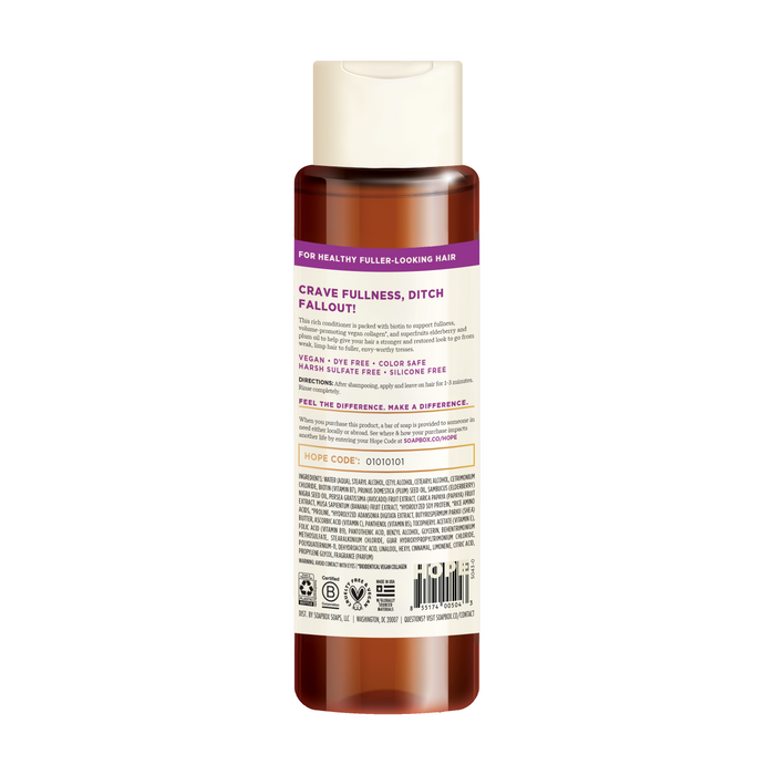 A bottle of Soapbox Biotin and Superfruit Restore & Volumize Conditioner features a purple label, white cap, with text promoting vegan collagen, color safety, and sulfate-free benefits for healthy, fuller-looking hair. It includes a product description and an ingredient list with biotin.