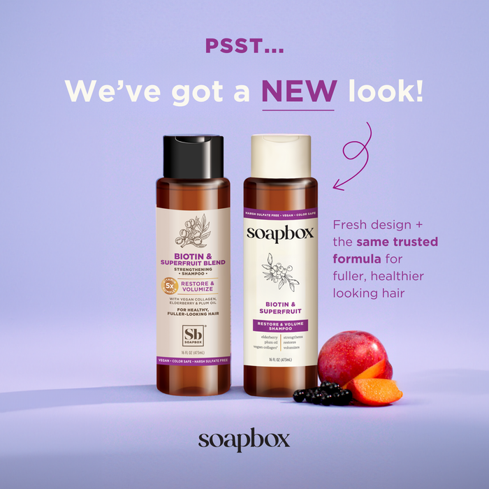 Two bottles of Soapboxs Biotin and Superfruit Restore & Volumize Shampoo showcase a new look but promise the same volumizing formula for healthier hair, featuring labels with biotin and superfruit blends like berries, pomegranate, and passionfruit.