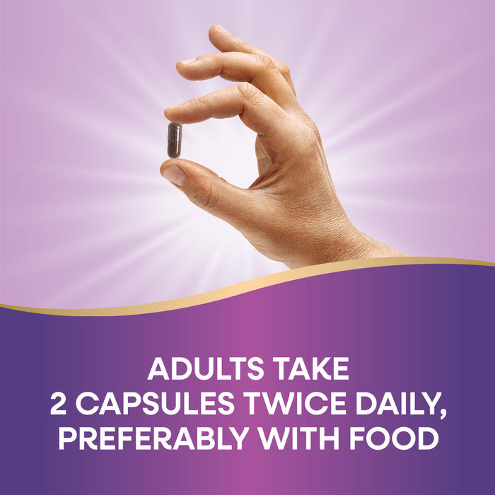 A hand holds a Natures Way Black Elderberry - For Traditional Immune Support capsule against a purple background with light rays. Text below reads: Adults take 2 capsules twice daily, preferably with food, for immune support.