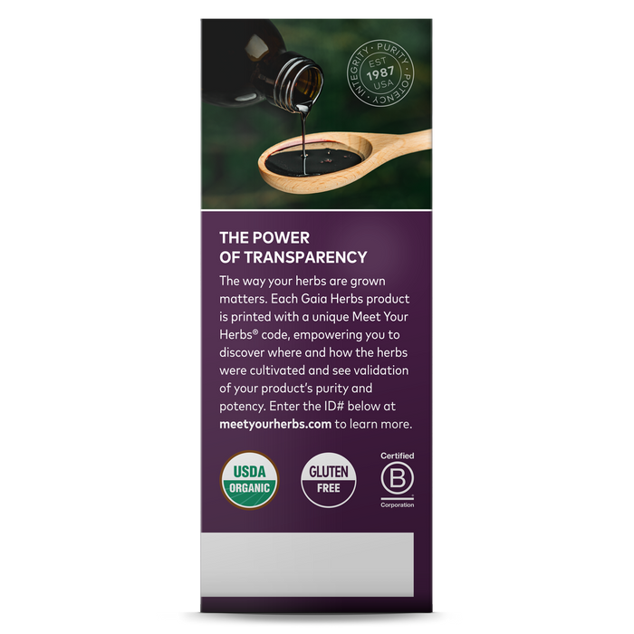 A Gaia Herbs sign features a wooden spoon with Black Elderberry Syrup pouring from a dark bottle, promoting transparency in herb sourcing. Includes USDA Organic, Gluten-Free, and Certified B Corporation symbols, plus website for immune support and organic Black Elderberries.