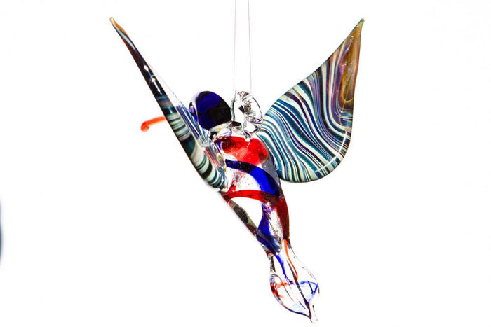 Blue and red cremation ashes swirl through a glass hummingbird with a hanging hook.