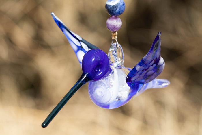 Blue and purple glass hummingbird ornament with crushed opal in the body and a beaded dangle of sodalite and amethyst.