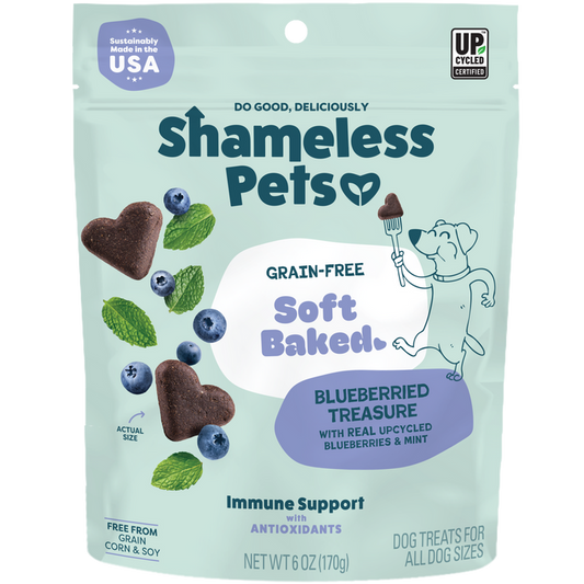 A package of Shameless Pets Blueberried Treasure Soft-Baked Dog Treats, featuring blueberries, heart-shaped treats, and a cartoon dog holding a fork.
