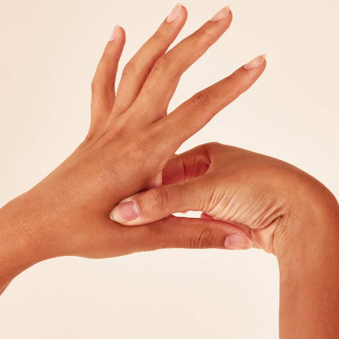 Two hands gracefully demonstrate flexibility against a neutral background, nails impeccably manicured. This image captures the essence of WTHNs Body Balance Magnets, highlighting skincare and stress reduction in your wellness journey.
