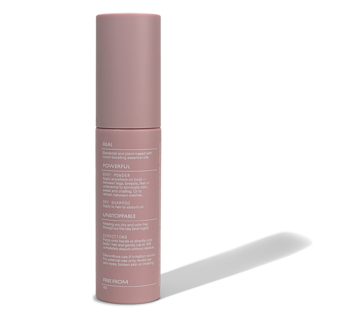 A pink cylindrical bottle labeled Cleo & Coco Body + Hair Powder features white text highlighting its use as a dry shampoo. The aluminum-free formula with natural arrowroot powder is described on the packaging, shown against a white background.