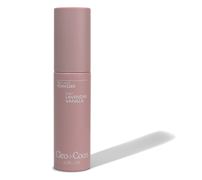 A tall, cylindrical pink container labeled Cleo & Coco Body + Hair Powder in Lavender Vanilla. This minimalist 2 oz (62 g) aluminum-free powder contains natural arrowroot powder.
