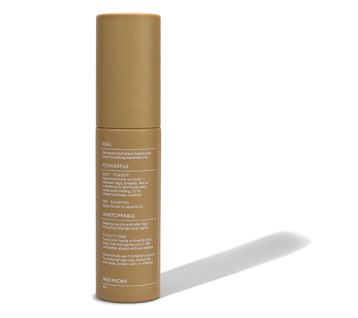 A gold cylindrical bottle with a cap displays white text describing Cleo & Coco’s Body + Hair Powder. This aluminum-free powder with natural arrowroot stands upright on a plain white background.