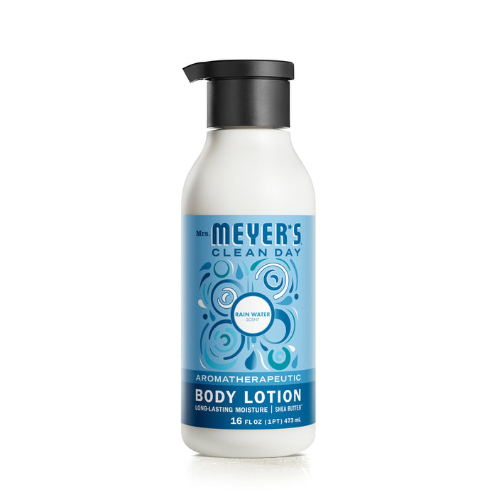 A 16 fl oz white bottle of Mrs. Meyers Body Lotion, Rain Water scent, features a blue label with bubbles and is enriched with shea butter for smooth skin. The garden-inspired fragrance offers long-lasting moisture and is naturally derived.