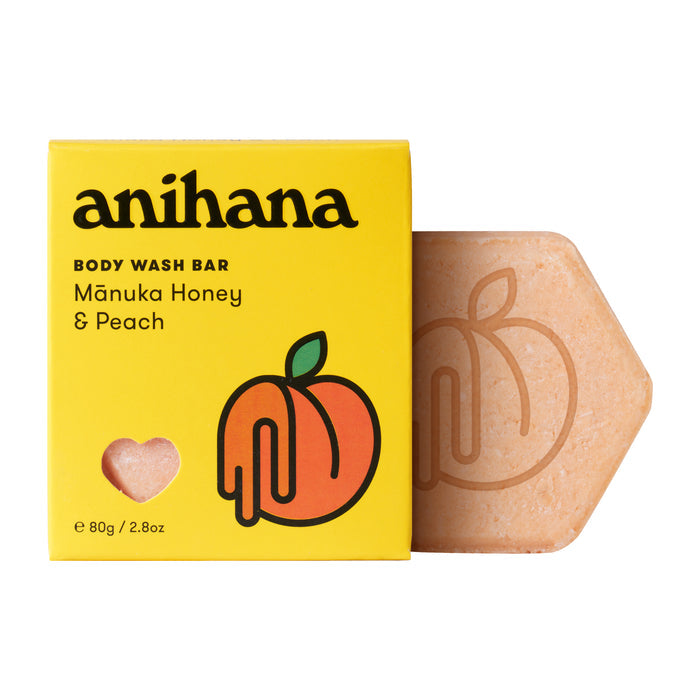 A yellow box labeled Anihana Body Wash Bar sits beside a peach-colored, hexagonal bar with an embossed design. The box has a peach illustration and a heart-shaped cutout.