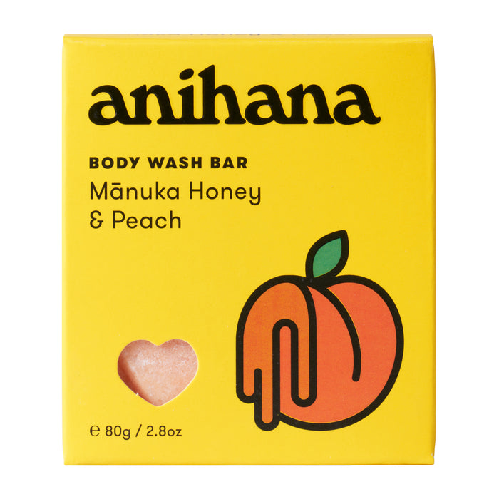 Anihana Body Wash Bar comes in a bright yellow box with a peach illustration, heart-shaped window revealing the bar, bold black text, and features the Mānuka Honey & Peach scent.