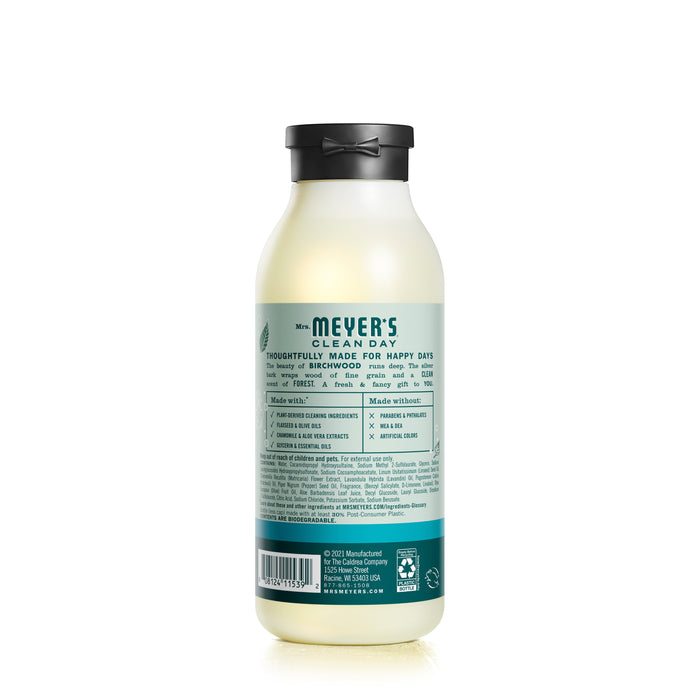 A light-colored bottle of Mrs. Meyers Body Wash with a black cap highlights garden-inspired fragrances, featuring a label with ingredients, usage instructions, and brand information that emphasizes natural ingredients and eco-friendly production.