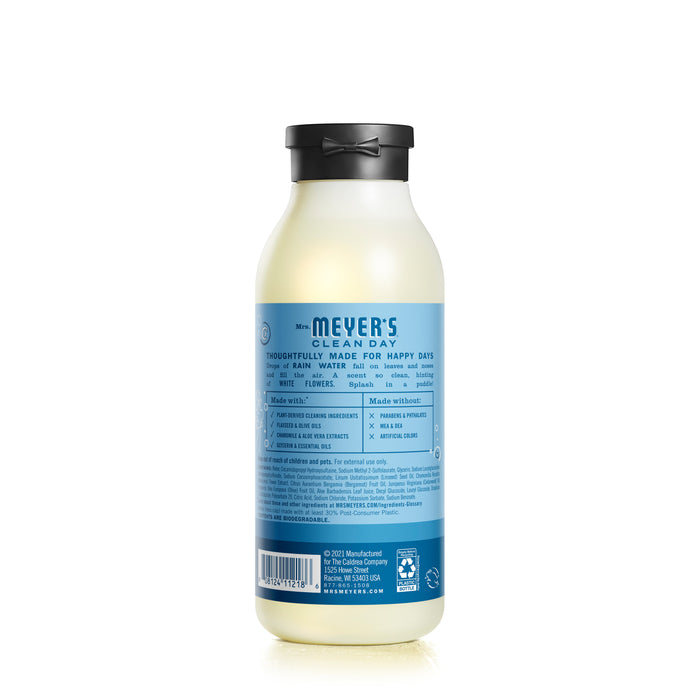 A Mrs. Meyers bottle in Rain Water scent, infused with essential oils for an eco-friendly touch. It features a light plastic design with a black cap and a blue label that displays ingredients in white text.