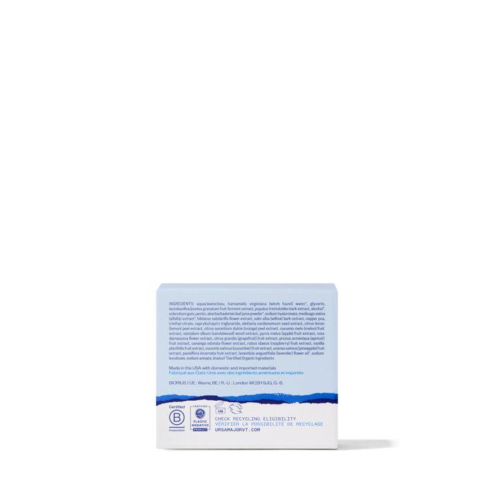 A blue and white box, shown from the back, displays ingredients, certifications, and recycling info. The Ursa Major Bright and Easy Flash Mask is part of a natural skincare line. The background is white and minimalistic.
