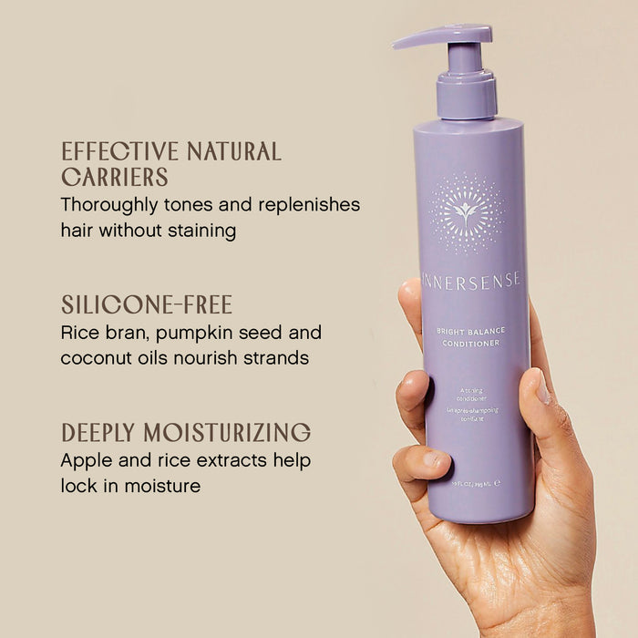 A hand holding a purple bottle of Innersense Bright Balance Conditioner with text describing its benefits: "Effective natural carriers," "Silicone-free," and "Deeply moisturizing." The bottle features a pump top.