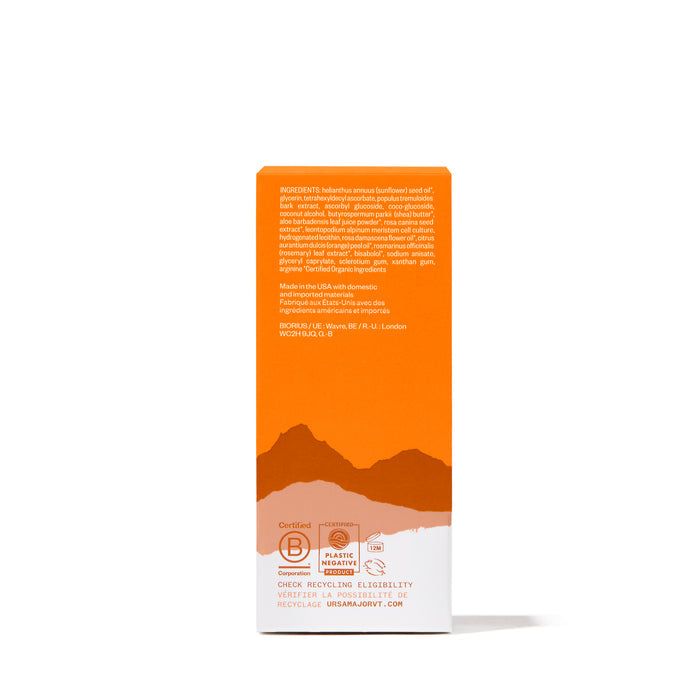 The orange and white box for Ursa Majors Brighten Up Vitamin C Serum lists ingredients, certifications, and recycling info, with a brown-toned mountain graphic below—reflecting the serum’s dual focus on skincare and sustainability.