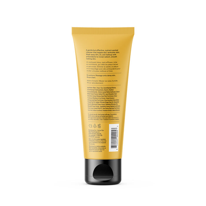 A yellow tube of Acure Brightening Cleansing Gel with a black flip-top cap is shown from the back, featuring mostly unreadable text and instructions. The plain white background highlights this Acure vegan cleanser.