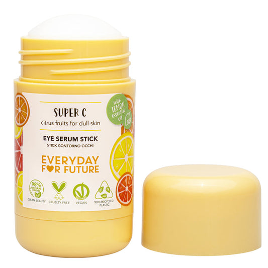 A yellow tube of Brightening Super C Solid Eye Serum Stick by Everyday For Future with the cap off reveals the white balm. The label shows citrus images and text noting its vegan, cruelty-free formula and eco-friendly qualities.