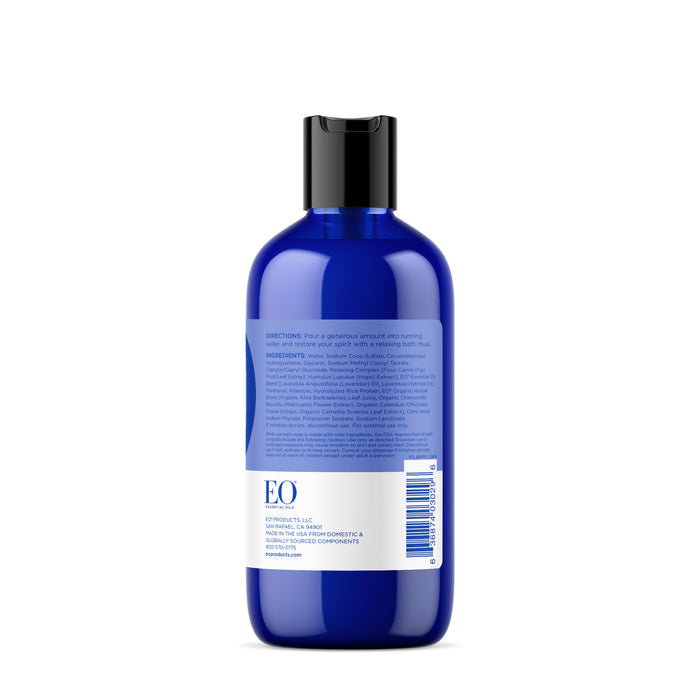 A blue plastic bottle features a black flip-top cap, displaying usage directions, ingredients, and a barcode. Its minimalist design showcases the vibrant blue hue and teases the calming essence of French Lavender Bubble Bath by EO Products.