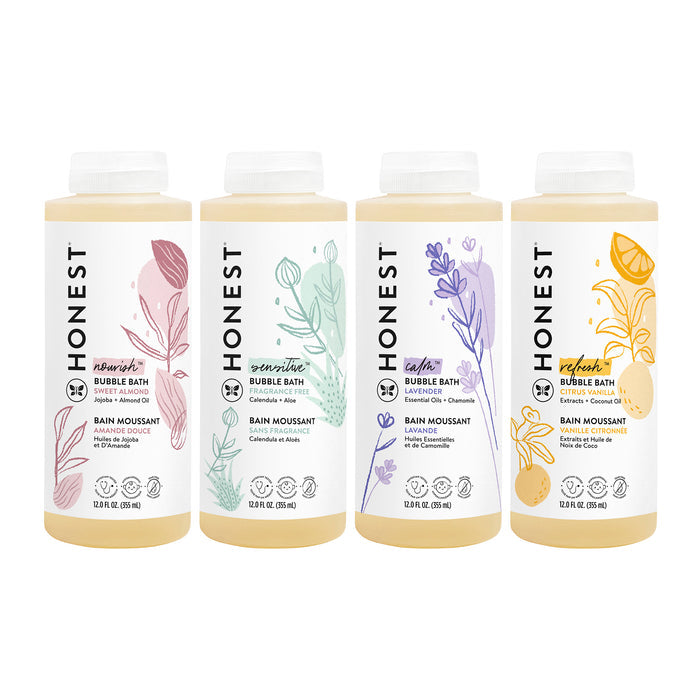 Four bottles of The Honest Company Bubble Bath are showcased, labeled Nourish, Sensitive, Calm, and Refresh. They feature vibrant red, green, purple, and yellow designs and contain 12 fl oz (354 mL) with chamomile extract for a soothing bath experience.
