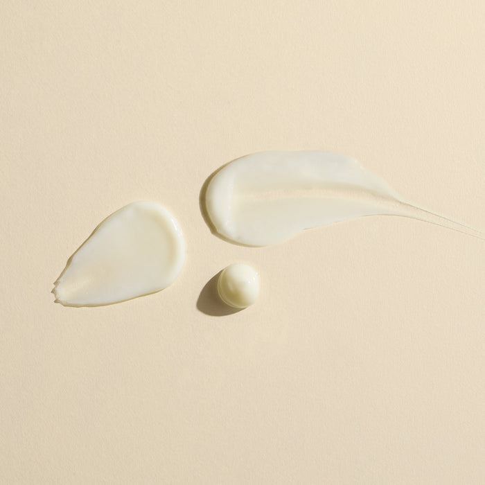 Wildcraft Calm Face Lotion is shown in two smooth swatches and a small dollop on beige, displaying its creamy white texture and lightweight hydration.