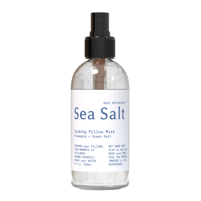 The clear Calming Pillow Mist by Muse Apothecary features a refreshing pineapple and ocean salt scent enriched with natural essential oils. Its 8 fl oz (236 ml) bottle has a black spray nozzle and highlights freshness, rest, and experience.