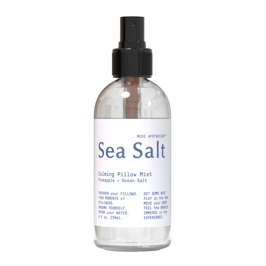The clear Calming Pillow Mist by Muse Apothecary features a refreshing pineapple and ocean salt scent enriched with natural essential oils. Its 8 fl oz (236 ml) bottle has a black spray nozzle and highlights freshness, rest, and experience.