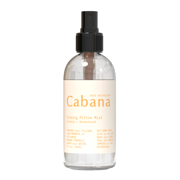 The Calming Pillow Mist from Muse Apothecary, labeled Cabana, is infused with coconut and sandalwood essential oils for tranquility. It comes in an 8 oz (236 ml) clear spray bottle with a black cap.