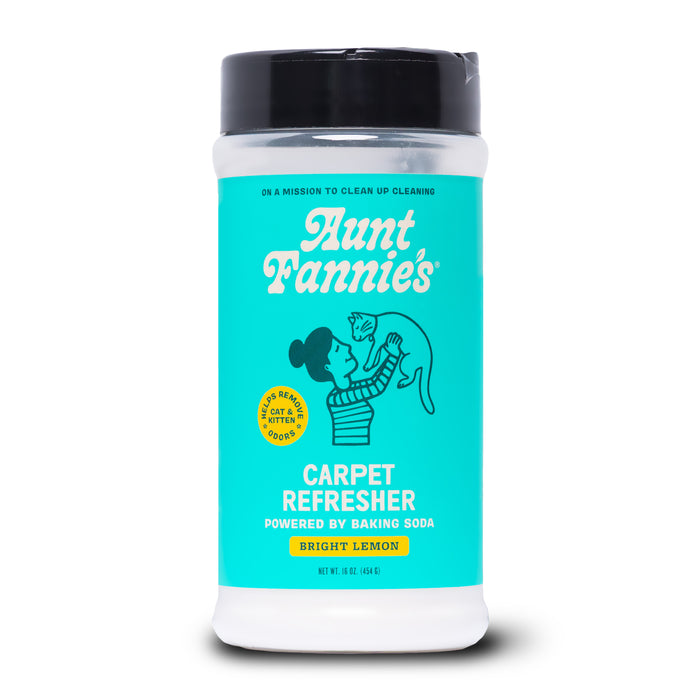 Aunt Fannies Carpet Refresher for Cats in Bright Lemon scent comes in a cylindrical container with a teal label featuring a woman holding a cat and highlights baking soda as a carpet and pet bed deodorizer.