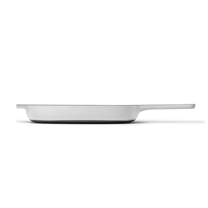 Side view of Caraways 10.5 Cast Iron Grill Pan, featuring a sleek, modern design with a long handle and non-toxic enamel coating. Its smooth edges and superior heat retention ensure perfect cooking, while the plain white background underscores its elegance.