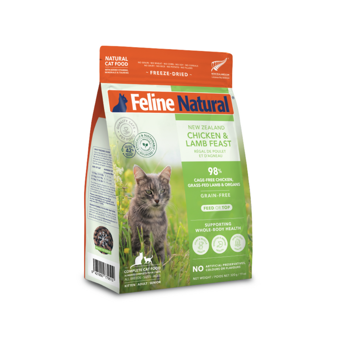 A bag of Feline Natural Grain-Free Freeze-Dried Cat Food displays a gray cat in grass and highlights natural New Zealand ingredients on its “Chicken & Lamb Feast” packaging.
