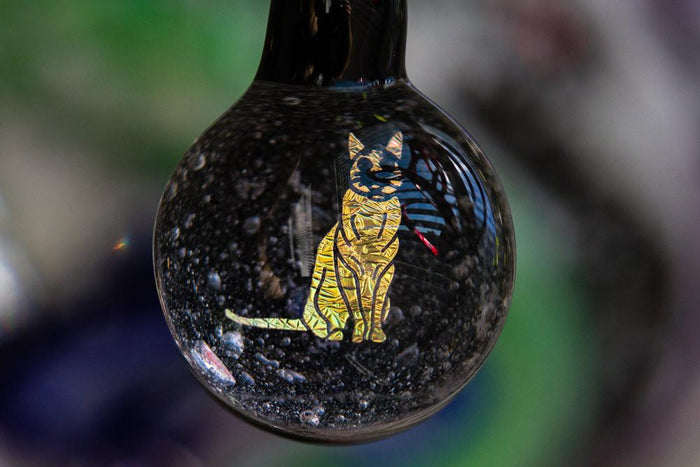 Borosilicate glass cat hologram pendant infused with cremation ash, suspended from an adjustable cord.