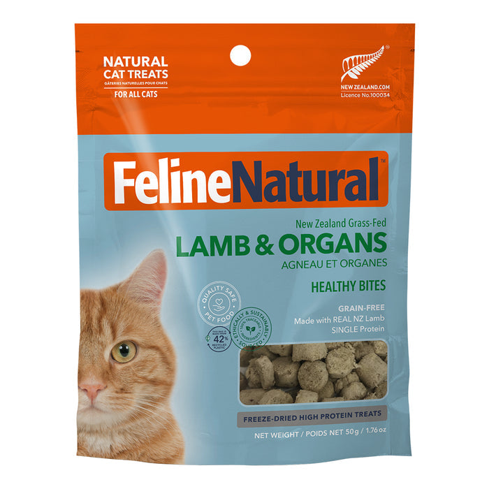 A bag of Feline Natural Grain-Free Freeze-Dried Cat Treats shows a close-up of an orange cat’s face on the left, treat pieces in a clear window at the bottom, and orange and blue packaging.