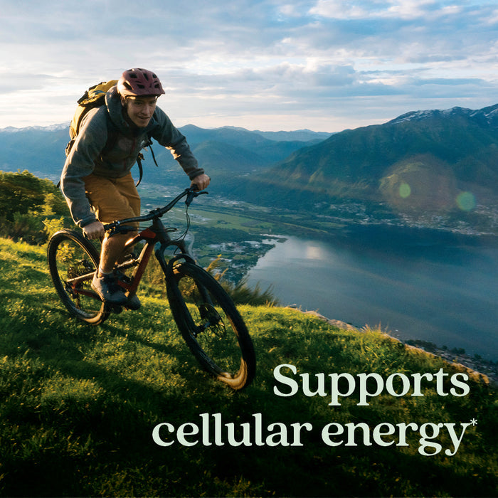 A person rides a mountain bike uphill on a grassy trail at sunset, with lake and mountains in view. “Supports cellular energy & healthy nerve function” appears beside New Chapter Cellular Energy Vitamin B12 + Gummies, Raspberry Flavored.