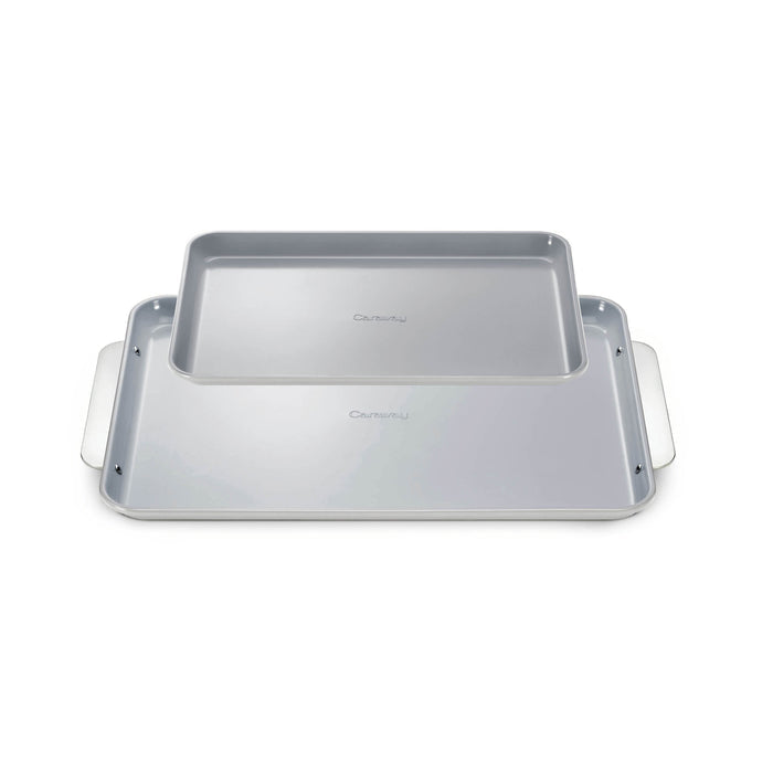 The Caraway Ceramic Baking Sheet Duo features two rectangular, naturally non-stick baking sheets. The smaller nests inside the larger, both with smooth surfaces and subtle side handles, boasting a light gray finish and modern design for healthy baking every time.