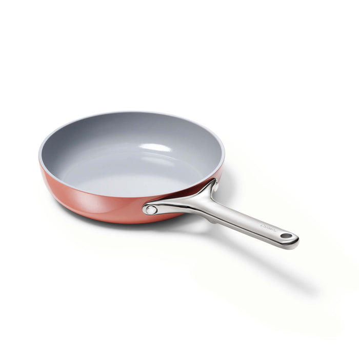 The Caraway Ceramic Fry Pan, 8 is showcased against a white background. This sleek, modern pan features a copper color with a silver handle and has a light gray interior.
