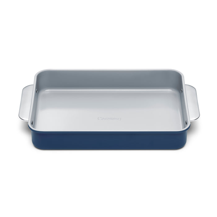 The Caraway Ceramic Rectangle Baking Pan features a blue exterior, light gray interior, and non-toxic ceramic coating. Its side handles and smooth, flat base make it ideal for healthy baking.