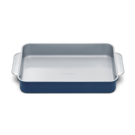 The Caraway Ceramic Rectangle Baking Pan features a blue exterior, light gray interior, and non-toxic ceramic coating. Its side handles and smooth, flat base make it ideal for healthy baking.