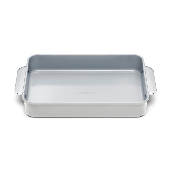 The Caraway Ceramic Rectangle Baking Pan is silver with rounded edges and two side handles. It features a non-toxic ceramic coating and a smooth, shiny interior, ideal for healthy, stick-free baking.
