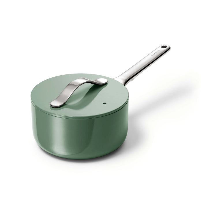 The Caraway Ceramic Sauce Pan with Lid, 1.75 qt, features a sleek green design with a matching lid and shiny silver handle. The lid boasts a curved silver knob, and its non-toxic coating ensures safe cooking for the family against a pristine white backdrop.