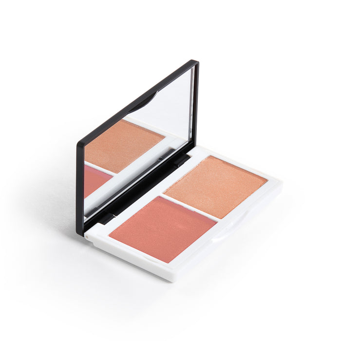 The Lily Lolo Cheek Duo features two natural blush shades, peach and pink. It comes in a sleek white case with a black edge and includes a rectangular mirror inside the lid, embodying clean beauty.