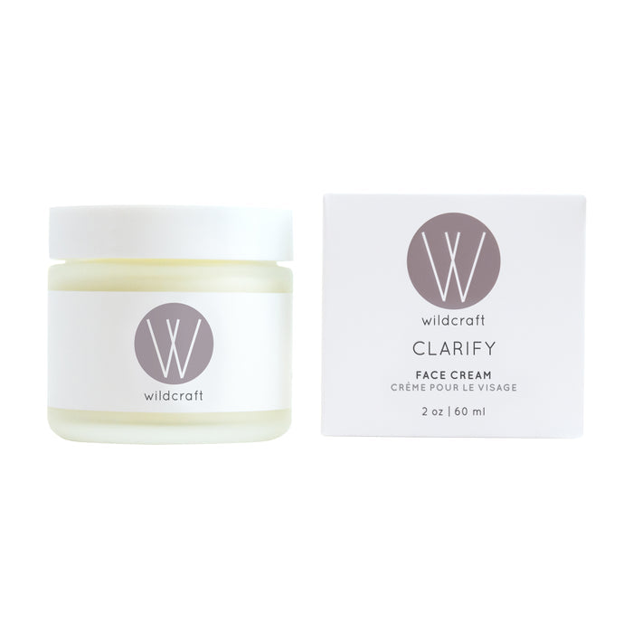 A jar and box of Wildcrafts Clarify Face Cream. The jar, leftmost, is white with silver branding, ideal for sensitive skin. The right box echoes this design. This 2 oz / 60 ml cream soothes dry skin.