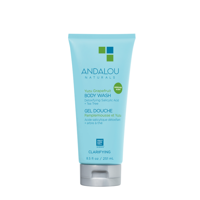 The blue 8.5 fl oz (251 ml) tube of Andalou Naturals Clarifying Yuzu Grapefruit Body Wash contains detoxifying salicylic acid and tea tree, with a bilingual English-French label highlighting its commitment to clean skincare.