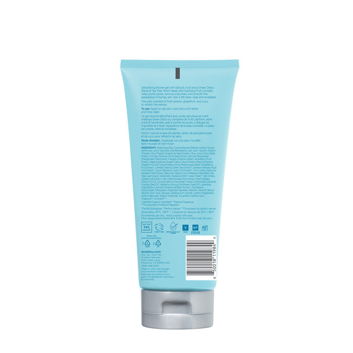 A blue tube with a silver cap, viewed from the back, features detailed text and a barcode, highlighting its role as Andalou Naturals Clarifying Yuzu Grapefruit Body Wash. The label shows ingredients and small icons for clean skincare details.