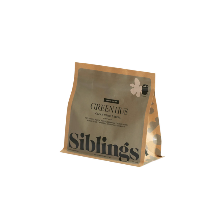 A tan and silver pouch labeled DIY Candle Kit by Siblings stands upright on a white background. The pack features a floral design, minimalist branding, and highlights its compostable packaging.