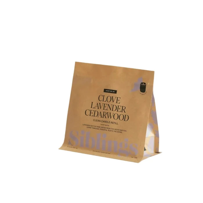 A brown paper package labeled "Clean Candle DIY Refill Kit" by Siblings stands upright on a white background, featuring compostable packaging and all-natural coconut-soy wax.