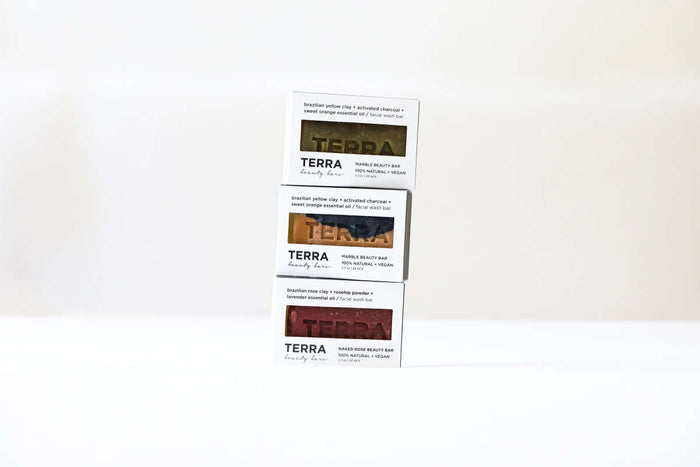 Three stacked Terra Beauty Bars of Brazilian yellow clays in distinct varieties: Clean Green Tea Tree Facial Beauty Bar, face mask, and cleansing powder. Each box features product details and branding on a white background, infused with Green Sea clay.