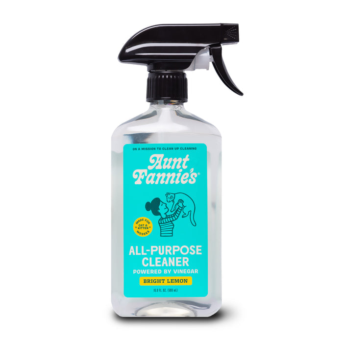 A spray bottle of Aunt Fannies Cleaning Vinegar For Cats features a blue label with a woman and child, and text noting plant-based cleaners powered by vinegar and essential oils.
